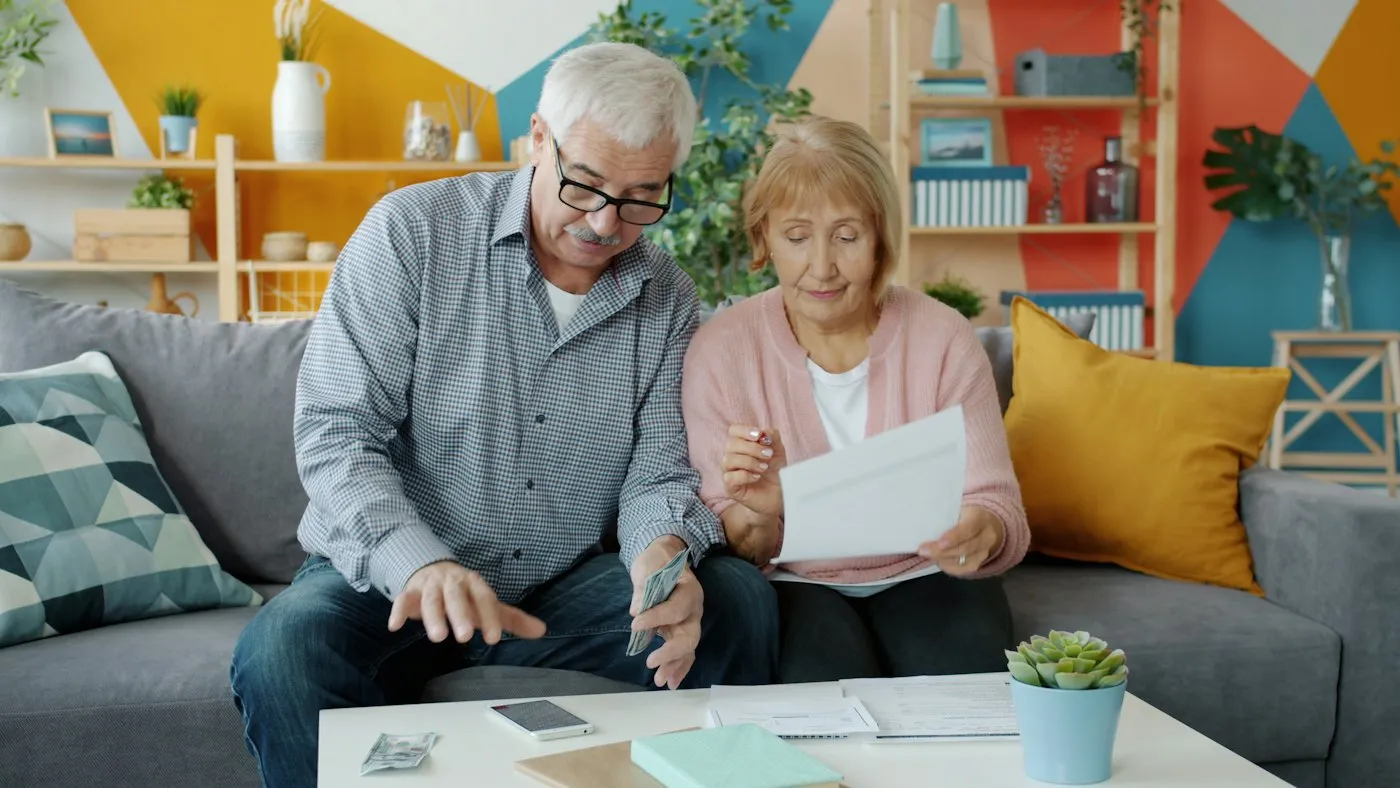 An older couple reviewing their home equity documents on the couch